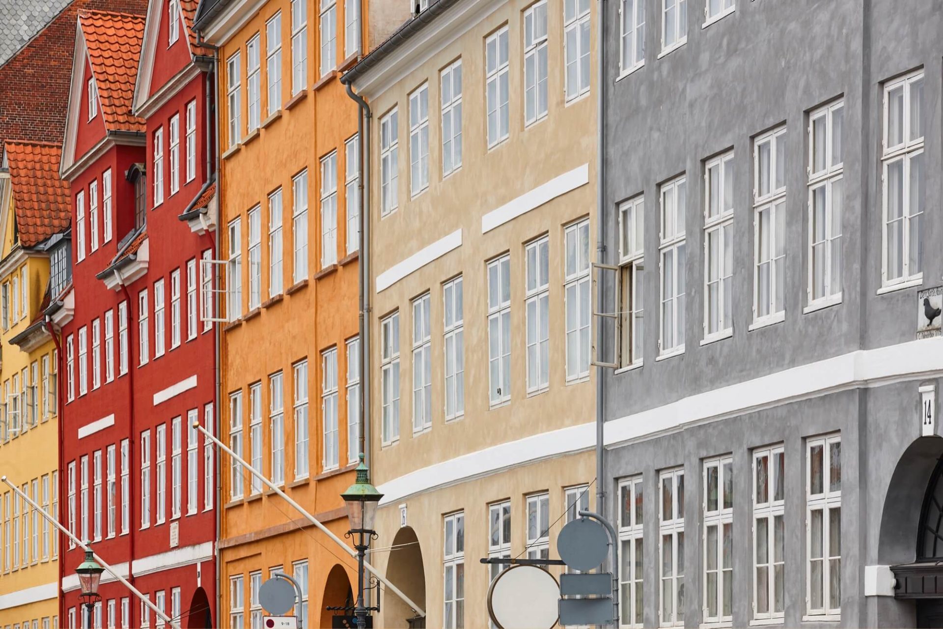 En serie färgstarka stadshus prydda med klassiska arkitektoniska detaljer i rött, gult och grått